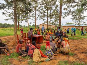Focus group in Ceru Hill, Kirundo Commune, Kirundo Province, Burundi. Group of people sitting on the ground, in an open space around a table where needs assessment is taking place